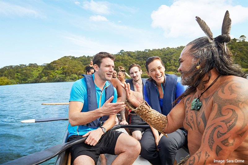 Group of people on a canoe with Maori leader in New Zealand
